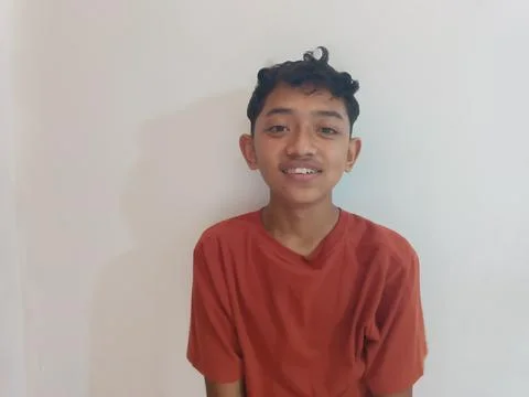 Smiling Teenage Boy in Red T-Shirt Against White Background Stock Photos