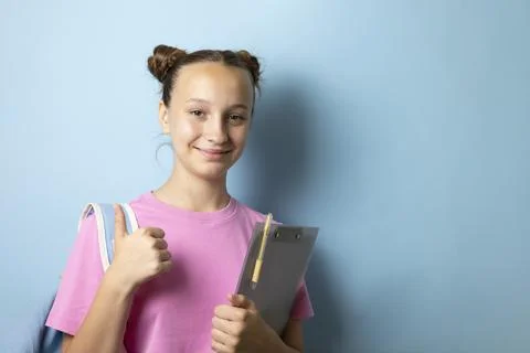 Smiling teenage student with backpack and notebook on color background Stock Photos