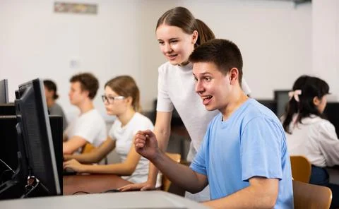 Smiling teenagers using computer during computer science lesson 스톡 사진