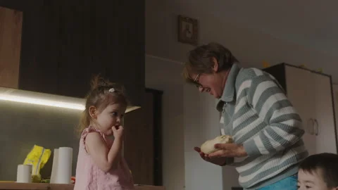 Smiling three generations having fun baking together with dough at home kitchen Stock Footage 248413521