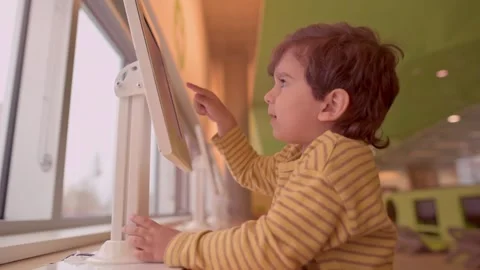 Smiling toddler boy having fun with digital application Stock Footage 246135146
