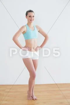 Smiling toned woman standing in fitness studio Stock Photos