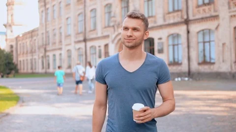 Smiling tourist drinking coffee on the run Stock Footage 99869001