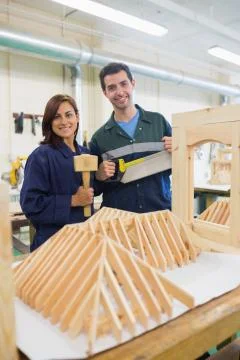 Smiling trainee and instructor standing behind construction Stock Photos