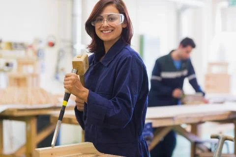 Smiling trainee using mallet and chisel Stock Photos