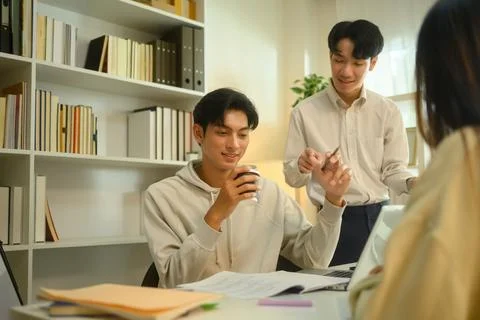Smiling tutor helping his students with assignment during a tutoring session Stock Photos