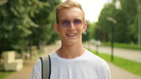 Smiling university student with a backpack and glasses on campus. Man enjoy.. Stock-Footage 339523524