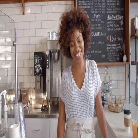 Smiling waitress behind counter at a coffee shop, close up 動画素材 69424404