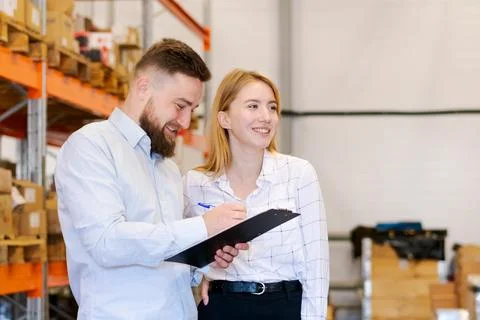 Smiling Warehouse Managers Working Together with Clipboard in Distribution .. Photos