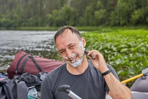 Smiling while shaving with razor in forest. Stock Photos
