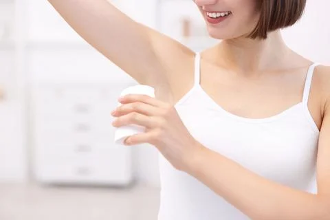 Smiling woman applying solid deodorant at home, closeup Stockfoto's