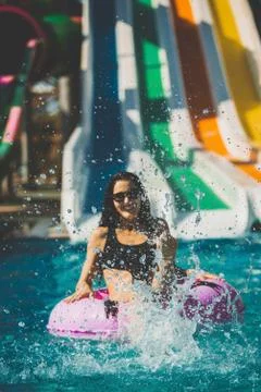 Smiling woman in bikini sitting in the pool on rubber ring Stock Photos
