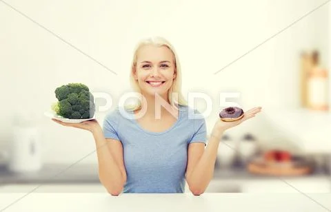Smiling Woman With Broccoli And Donut On Kitchen