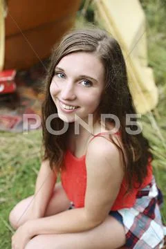Smiling woman crouching at camping tent Stock Photos
