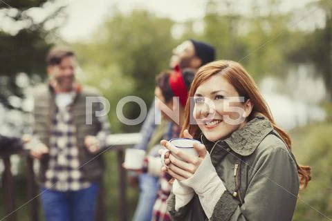 Smiling woman drinking coffee on balcony Stock Photos