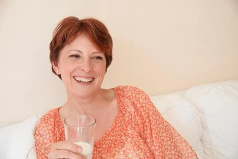 Smiling woman drinking glass of milk Stock Photos