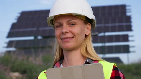 Smiling woman engineer in safety vest and hard hat holding digital tablet a.. Stock Footage 333581453