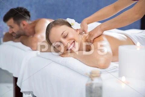 Smiling woman enjoying massage and man in spa Stock Photos