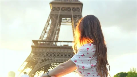 Smiling woman in front of Eiffel Tower at sunset in Paris Stock Footage 313796762
