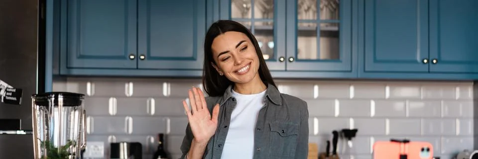 Smiling woman gesturing while taking selfie footage on cellphone Stock Photos