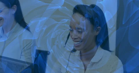 Smiling woman with headset working at computer over swirling blue animation Stock Footage 304762082