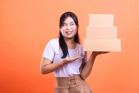 Smiling woman holding a stack of boxes. 스톡 사진
