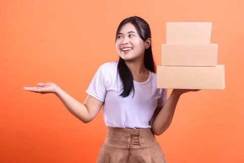 Smiling woman holding stack of boxes Foto stock