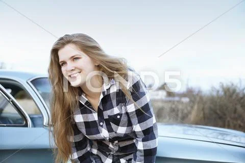 Smiling woman leaning on vintage car Stock Photos