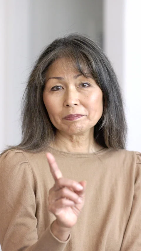 Smiling woman looking at camera making humorous finger gesture to stop  Stock Footage 331221219