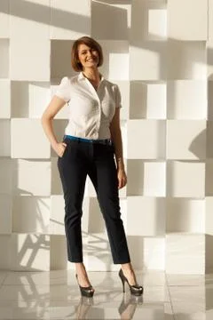 Smiling woman looking at camera while holding hand in pocket 写真素材