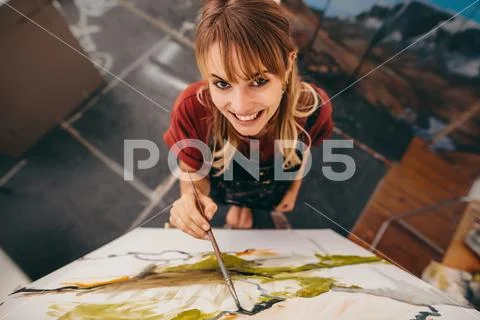 Smiling woman painter drawing on canvas Stock Photos