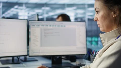 Smiling woman at PC checking servers bottlenecks leading to malfunctions Stock-Fotos