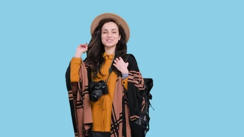 Smiling woman posing with backpack and camera during trip on the blue chroma key Stock Footage 274843364