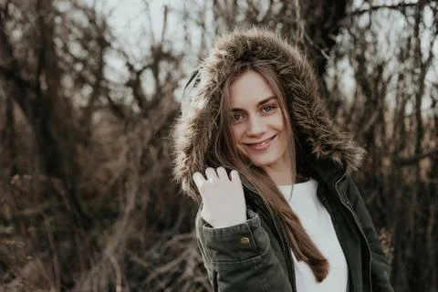 Smiling woman posing on camera in jacket with fur hood Stock Photos