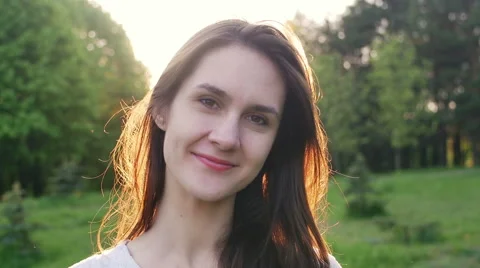 Smiling woman in the rays of the setting sun Stock Footage 63306364