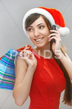 Smiling woman in Santa Claus clothes with phone Stock Photos