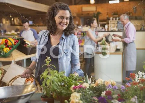 Smiling woman shopping for flowers in market Stock Photos