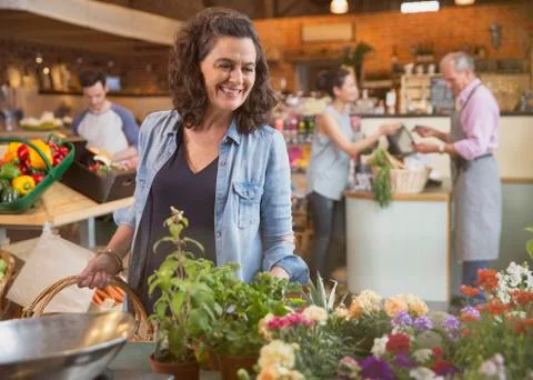 Smiling woman shopping for flowers in market Stock Photos