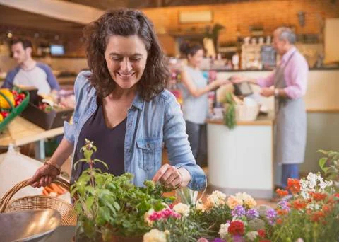 Smiling woman shopping for flowers in market Stock Photos
