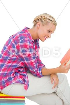 Smiling woman sitting on a stack of books Stock Photos