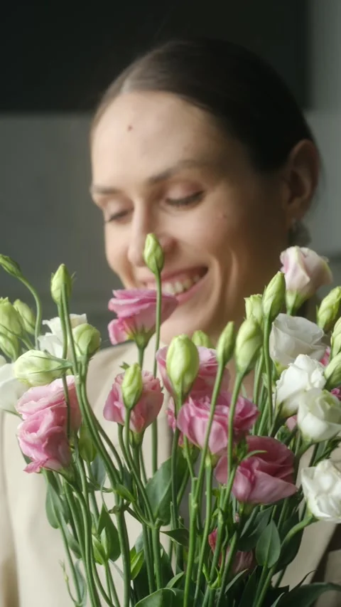 Smiling woman smelling a fresh eustoma bouquet Stock Footage 337830405