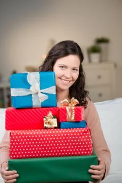 Smiling woman with a stack of gift boxes Foto stock