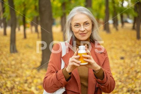 Smiling woman standing in a city park Stock Photos