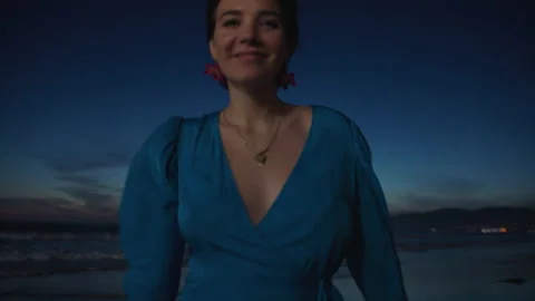 Smiling woman turning looking at camera at dusk Stock Footage 178413301
