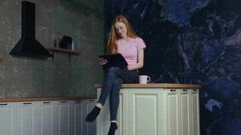 Smiling woman using digital tablet at home reading or searching recipe. Modern 스톡 동영상 168597547