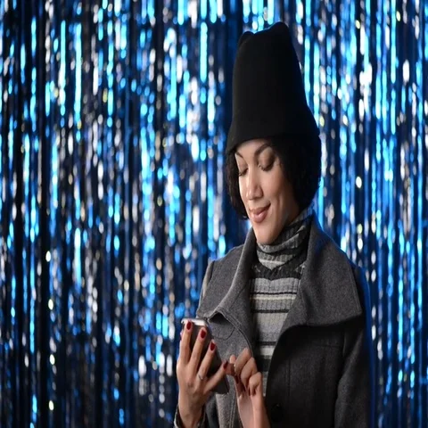 Smiling woman using her mobile phone over lights Stock Footage 69405529