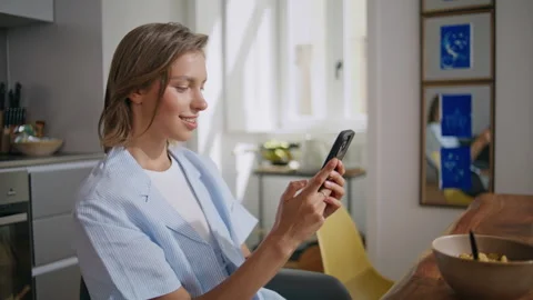Smiling woman using mobile phone during breakfast closeup. Happy student resting Stock Footage 333109729