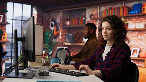 Smiling woman using programming languages on PC in IT startup office Stockfoto's
