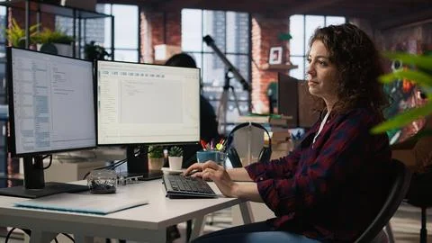 Smiling woman using programming languages on PC in IT startup office 스톡 사진