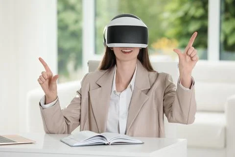 Smiling woman using virtual reality headset in office Stock Photos